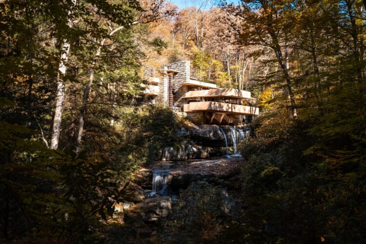 Alt text: "Architectural masterpiece nestled in autumn forest with cascading waterfall - visit iconic House on Waterfall, perfect destination for architecture and nature enthusiasts seeking serene landscapes for their next getaway."