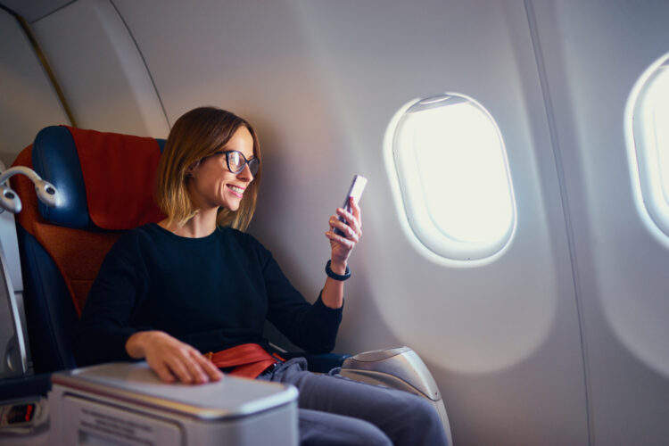 A woman reading on her iphone on an airline