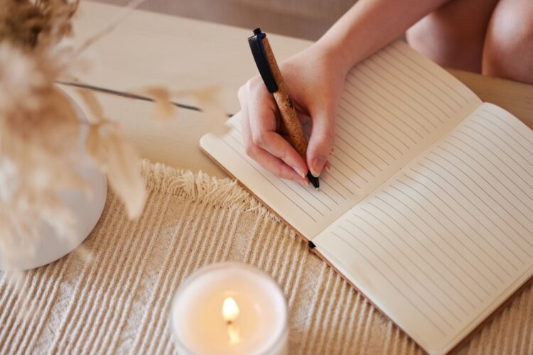woman writing into a journal
