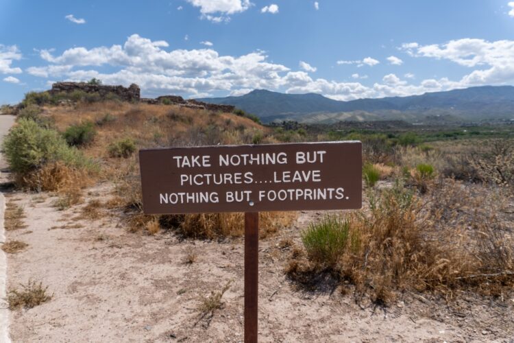 Sign in desert that says "take nothing but pictures" and leave nothing but footprints