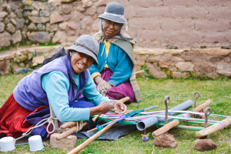 native american mother and daughter weaving authentic aymara cloth.