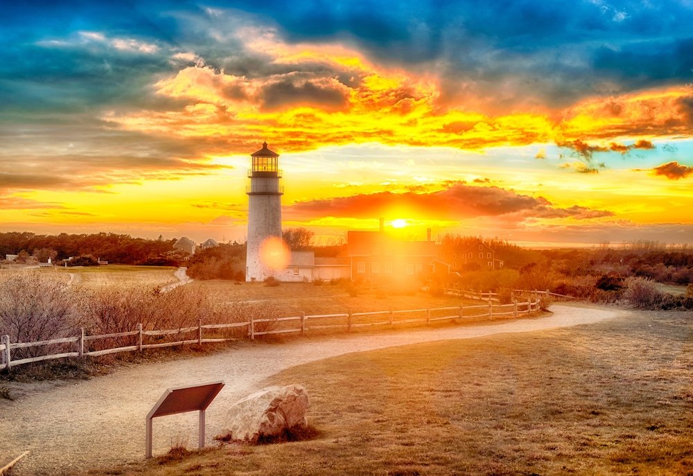 The Highland Lighthouse against a beautiful dramatic sunset in North Truro Massachusetts on the Cape Cod National Seashore.