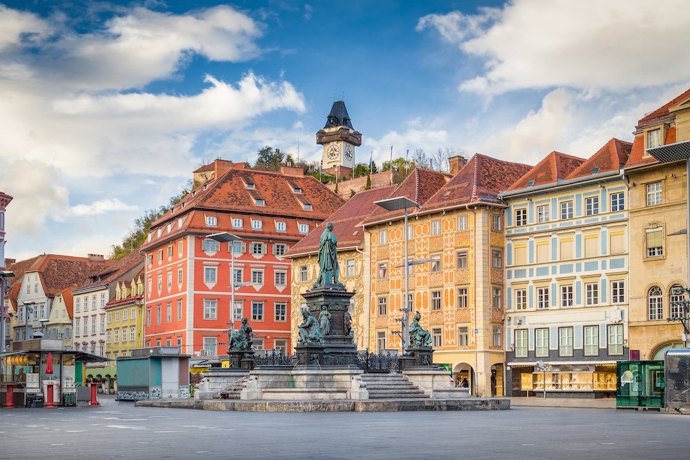 Classic view of the historic city of Graz with main square and famous Grazer clock tower in the background sitting on top of Schlossberg hill